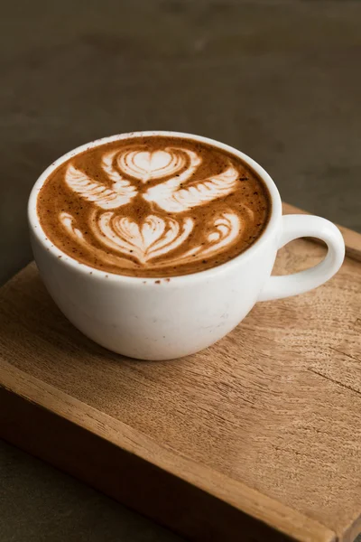 Κούπα ζεστό καφέ latte art σε ξύλινο τραπέζι — Φωτογραφία Αρχείου