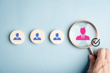 El ele tutuşan büyüteç, bir grup insandan öne çıkan adayları seçmek, işe alım konsepti, insan kaynakları, eleman alımı ve yetenek edinme süreci.