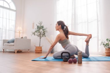 Esneme egzersizi. Kadınlar evlerinde yoga minderleri üzerinde hareketlilik akışı yapıyor, esneklik eğitimi, temel kuvvet ve sağlıklı yaşam tarzı gösteriyor.