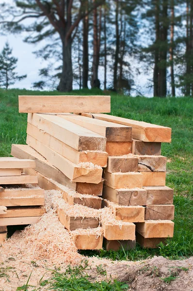 Wooden planks, sticks, blocks on the grass in a forest. — Stock Photo, Image