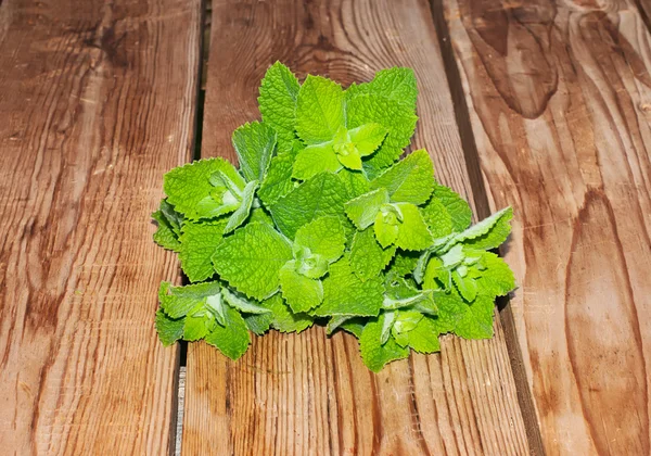 Fresh mint leaves on a wooden background. — Stock Photo, Image