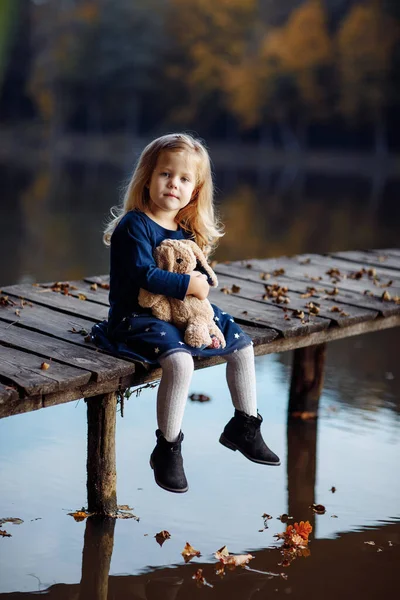 Pequena Menina Bonita Segurando Brinquedo Suas Mãos Parque Outono Perto — Fotografia de Stock