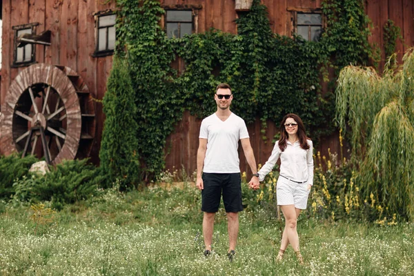 사랑하는 남녀는 여름날커다란 방앗간 근처를 걷습니다 남자와 여자는 밖에서 즐거운 — 스톡 사진