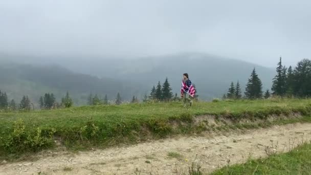 Boldog kislány fut és ugrál gondtalanul tárt karokkal a felhős hegyekben. Amerikai zászló van a kezében. szelektív fókusz. — Stock videók