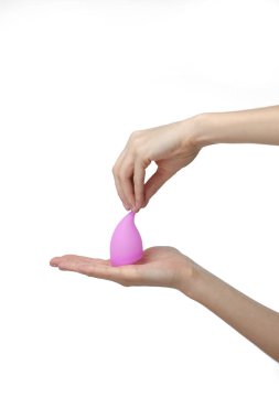 Pembe menstrüel fincanı tutan genç bir kadın. Beyaz arka plan. Jinekoloji konsepti