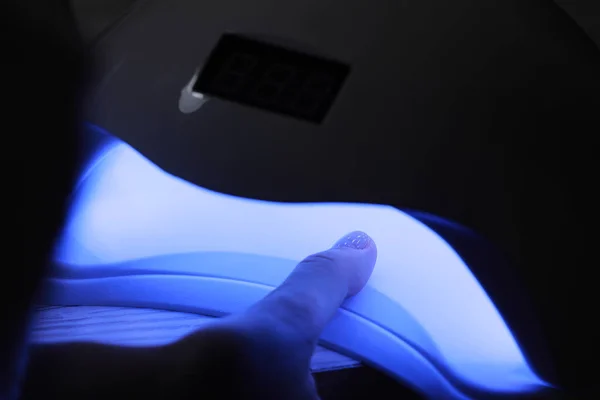 ジェルポリッシュマニキュアで女性の手のクローズアップビュー 女性はマニキュアのトップカバーを硬化させるために鉛紫外線ランプに手を置きます Uvランプ Ledネイル — ストック写真