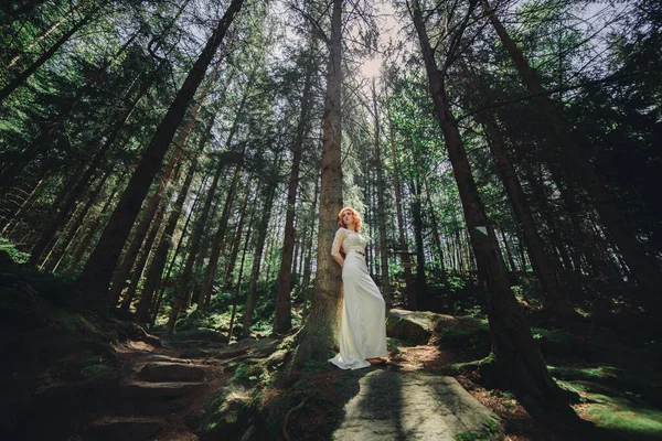 Νεαρή Κοκκινομάλλα Νύφη Λευκό Μακρύ Φόρεμα Ένα Καταπράσινο Δάσος Την — Φωτογραφία Αρχείου