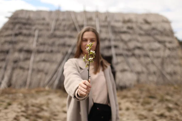 Vacker Ung Kvinna Håller Blommande Gren Bakgrund Ett Gammalt Halmhus — Stockfoto