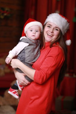 Genç, çekici, mutlu anne oğluyla Noel ağacının yanında iyi vakit geçiriyor. Aile, mutluluk, tatiller, yeni yıl konsepti