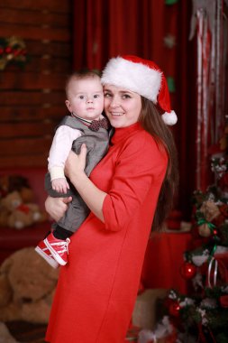 Genç, çekici, mutlu anne oğluyla Noel ağacının yanında iyi vakit geçiriyor. Aile, mutluluk, tatiller, yeni yıl konsepti