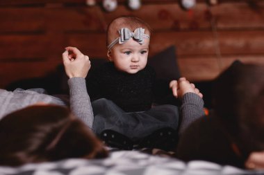 Yatakta genç ve tatlı bir aile ve arkasında Noel geçmişi var. Anne, baba ve bebek birlikte vakit geçirin..