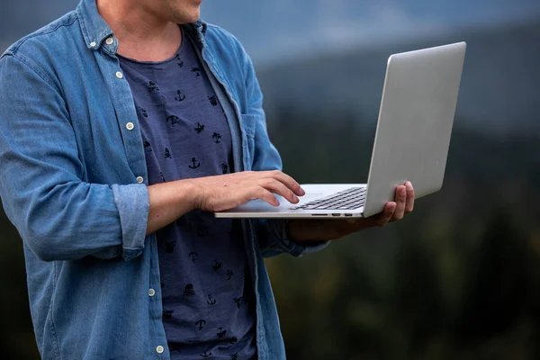 Homem trabalhando ao ar livre com laptop em montanhas. Conceito de trabalho remoto ou estilo de vida freelancer. Cobertura de banda larga de rede celular. Internet 5G. — Fotografia de Stock