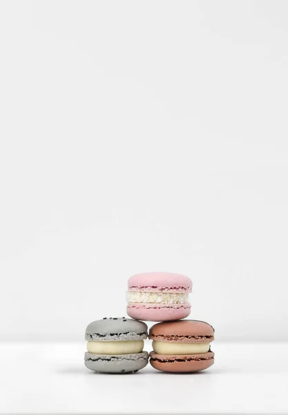 Três Macarons Macaroons Franceses Coloridos Rosa Marrom Cinza Fundo Branco — Fotografia de Stock