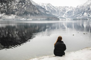 Gezgin-İmaj. Gezgin kışın dağ gölüne bakar. Seyahat ve aktif yaşam konsepti. Avusturya 'nın dağlık bölgelerinde macera ve seyahat.