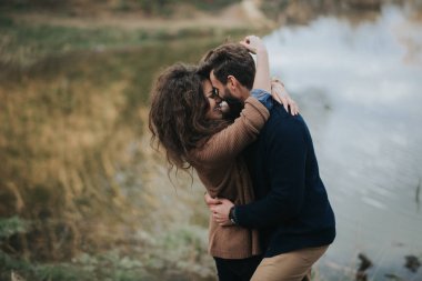 Göl kenarında iki Kafkasyalı aşık. Genç çift, sonbahar günü dışarıda kucaklaşıyor. Sakallı bir adam ve birbirine aşık kıvırcık bir kadın. Sevgililer Günü. Aşk ve aile kavramı.