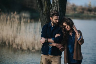 İki Kafkasyalı aşık gölün yanındaki ağacın yanında duruyor. Genç çift, sonbahar günü dışarıda kucaklaşıyor. Sakallı bir adam ve birbirine aşık kıvırcık bir kadın. Sevgililer Günü. Aşk ve aile kavramı