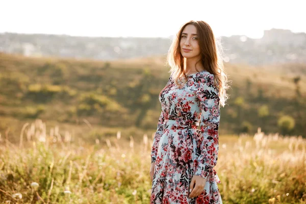 Mooie Jonge Vrouw Jurk Bloemenprint Wandelen Het Veld Bij Zonsondergang — Stockfoto