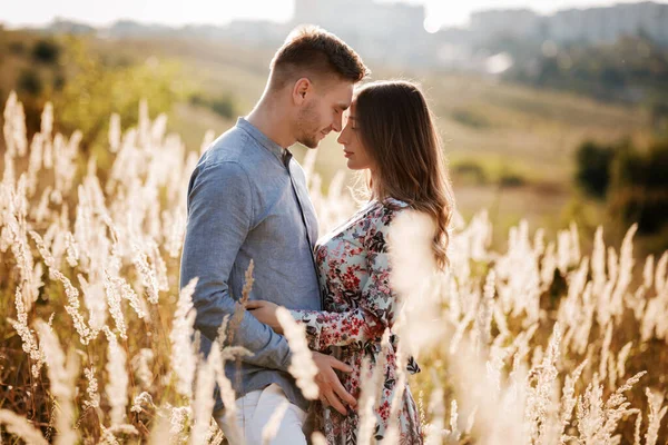 Genç ve sevgi dolu bir çift yazın açık havada kucaklaşıyorlar. Mutluluk ve aşk kavramı. Fotoğrafı kapat. Aşk hikayesi.