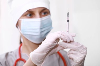 Şırınga, elinde tıbbi enjeksiyon, avuç içi ya da parmak. İğneli tıbbi plastik aşı ekipmanı. Hemşire ya da doktor. Sıvı uyuşturucu ya da uyuşturucu. Hastanede sağlık hizmeti.