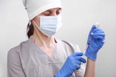 Biyolojik tehlike. Çin koronavirüsü salgını. Doktor, hemşire, koruyucu kıyafetli ve maskeli bilim adamı şırınga ve aşı tutuyor. Grip aşısı, koronavirüs, ebola, tüberküloz