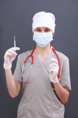 Doktor, tıbbi maske, steteskop ve eldiven giyen hemşire grip, kızamık, koronavirüs, kovid-19 aşı hastalığı insan klinik denemeleri aşı aşısı, ilaç ve ilaç konseptine hazırlanıyor.