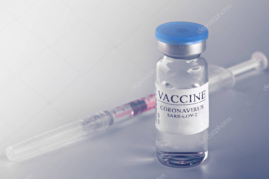 Medicine bottle with coronavirus vaccine covid-19. Medical glass vial and syringe for vaccination. liquid vaccine in laboratory, hospital or pharmacy concept isolated on blue background.