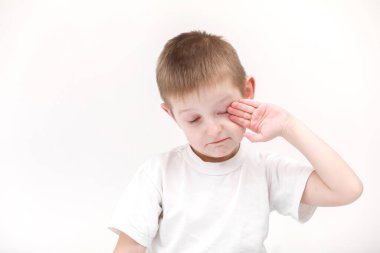 Mutlu küçük bir çocuğun portresi. Sabah uyandığında beyaz bir arka planda tek başına. Temiz ve rahat çarşaflar. Çocuklar için yatma zamanı. Mutlu rüya kavramı.