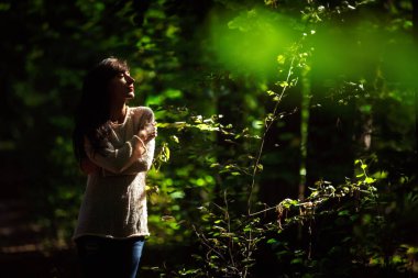 Güneşin altındaki ormanda gözleri kapalı güzel bir genç kadının portresi..