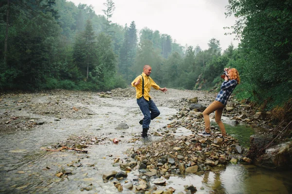 Ormanda yürürken eğlenen mutlu ve yakışıklı bir çift. Dağlarda turistler. Doğa konseptinde macera. Dağlarda bir çift — Stok fotoğraf