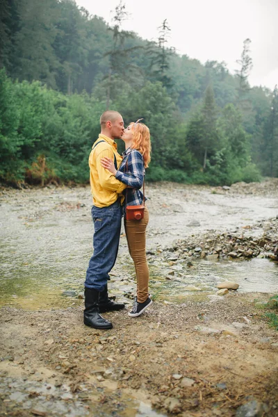 Playful happy handsome couple having while walking in woods. tourists in the mountains. Adventure in nature concept. couple in the mountains