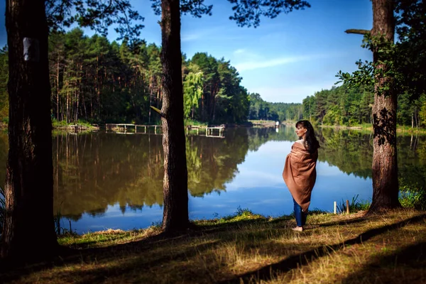 Egy lány pózol egy tó vagy folyó hátterében. séta a természetben — Stock Fotó