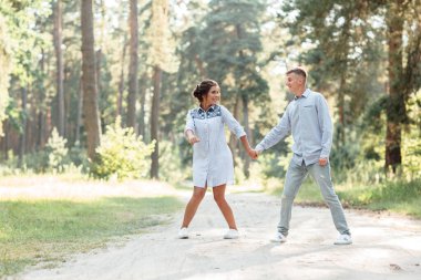 Genç aşıklar güzel yaz doğasının tadını çıkarıyorlar. Kot pantolon giyen kadın ve erkek, parkta buluşuyorlar. Romantik bir ilişki. Sevgililer Günü.