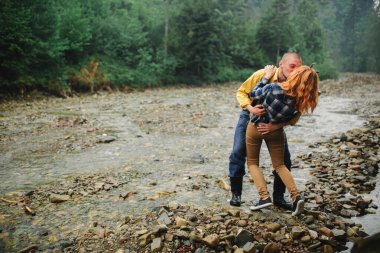 Ormanda yürürken eğlenen mutlu ve yakışıklı bir çift. Dağlarda turistler. Doğa konseptinde macera. Dağlarda bir çift.