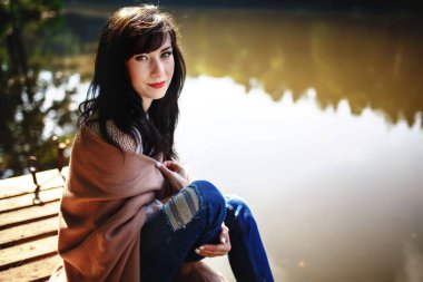 Köprüde oturan uzun esmer saçlı güzel kız. Doğa.