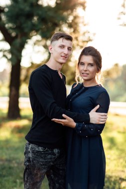 Neşeli genç kadın ve erkek yaz parkında kucaklaşıyorlar. Birbirine aşık çiftler gün batımında romantik bir tatile çıkıyorlar. Gençler arasındaki aşk ve ilişkiler