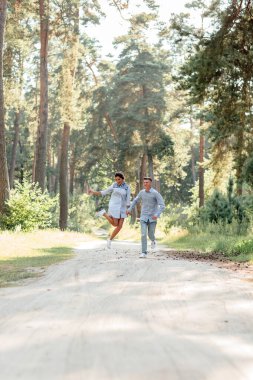 Genç aşıklar güzel yaz doğasının tadını çıkarıyorlar. Kot pantolon giyen kadın ve erkek, parkta buluşuyorlar. Romantik bir ilişki. Sevgililer Günü.