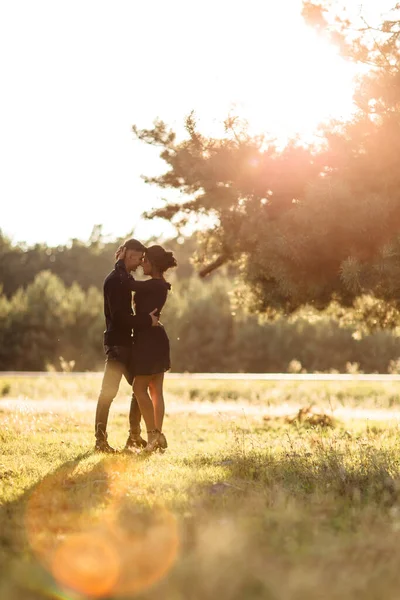 年轻夫妇在夏日公园里手牵手散步 穿着黑色衣服的男女日落时在户外约会 浪漫的关系 情人节 — 图库照片