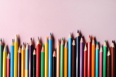 Renkli kalemler seti, sıra sıra pembe arka planda izole edilmiş tahta kalemler. Çizim için renkli kalemler. Boşluğu kopyala