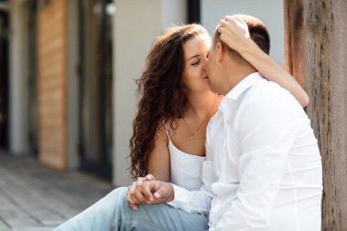 Neşeli kadın ve erkek portresi ve dışarıda oturmak, öpüşmek, sarılmak ve gülmek sevgililer gününde sevgili olmak..