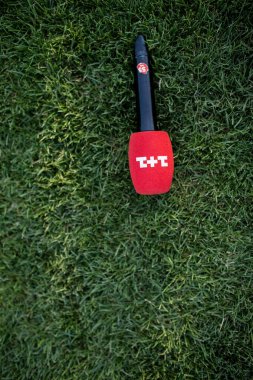 Ukrayna - 27 Haziran 2020. Siyah-kırmızı kablosuz mikrofon, her tür etkinlik için yeşil çimenlerin üzerine beyaz metin 1+ 1 kanalı ile döşendi. Haber ve duyuru için mikrofon.