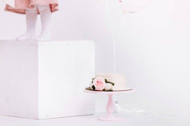 Beyaz stüdyoda 2 yıllık mum ve güllerle süslenmiş güzel beyaz kremalı pasta. Doğum günü partisi - Doğum yılı kavramı, parti, yaşam kutlaması ve unutulmaz anlar