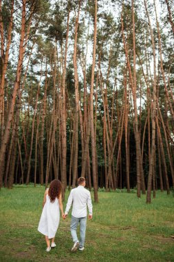 Genç aşıkların tam boy portresi. Güneşli yaz günlerinde güzel ormanın tadını çıkarıyor ve eğleniyorlar..