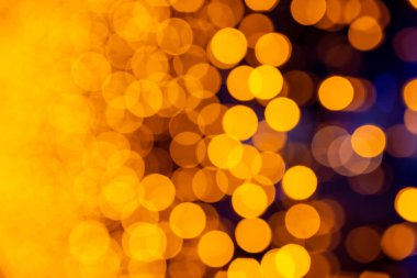 Noel ışıklarının soyut yuvarlak arka planı. Çelenklerden Bokeh. Ekran koruyucu için arkaplan. Odaklanamayan ışıklar. Sarı ışıklarla bulanık bokeh