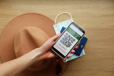 Pasaport ve Covid-19 hastalığına karşı aşı sertifikası olan akıllı bir telefon. Akıllı telefona odaklan. Sağlık Pasaportu konsepti. Dünyayı dolaş.