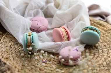 Pembe ve naneli Fransız kurabiyeleri veya badem kurabiyeleri ve bez bir arka planda beyaz çiçekler. Doğal meyve ve böğürtlen tatları, sevgililer günü için kremalı dolma anneler günü paskalyasında aşk yemeği..