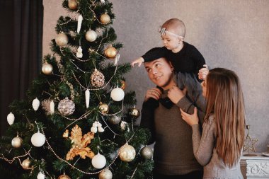 Mutlu aile Noel ağacını süslüyor. Aile yeni yıla hazırlanıyor..