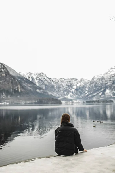 Traveler-Image. Traveler look at the mountain lake in winter. Travel and active life concept. Adventure and travel in the mountains region in the Austria, Hallshtat