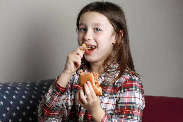 귀엽고 귀여운 소녀가 감정적으로 햄버거 샌드위치 버거를 집에서 미소짓고 있습니다 — 스톡 사진