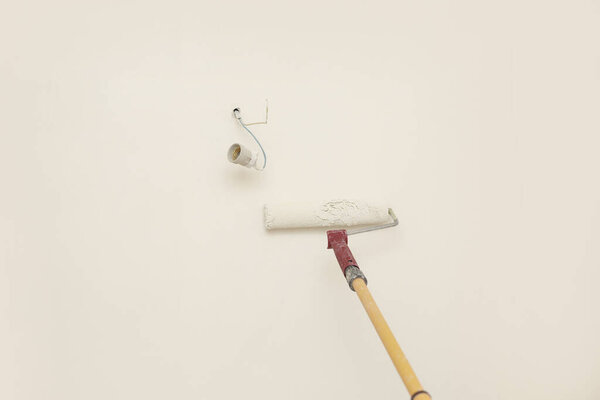 Стена мужской ручной росписи с роликом краски. Живопись квартиры, ремонт с белым цветом краски. Ремонт комнат в доме