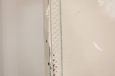 İşçi yeni dairede metal duvar profilini oluşturdu. Alçıpanlı metal profiller. Alçı taşı kurulum arkaplanı. Duvarlar için metalik malzeme.